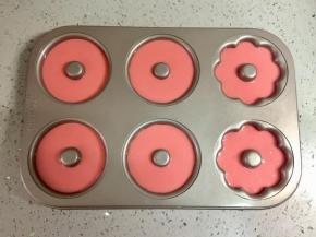 在裱花袋底部剪一个合适的口，把面糊挤进甜甜圈模具。不粘模具可以直接挤，如果是硅胶的，建议先刷一层油，方便脱模。