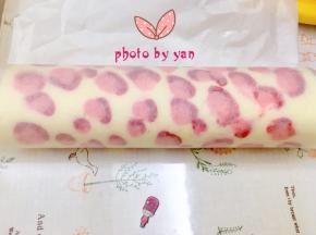 用擀面杖卷住油纸，顺势往上推，卷起来，两边跟拧糖一样拧起来。放入冰箱冷藏半小时后再切块食用。