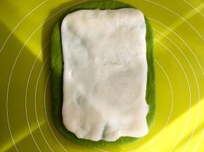 之后一点点取下保鲜袋，将麻薯面片放在抹茶面团中间