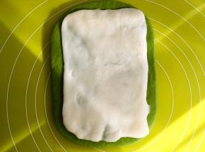 之后一点点取下保鲜袋，将麻薯面片放在抹茶面团中间