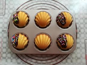 在玛德琳蛋糕上刷上适量的巧克力酱，沾上适量的彩色糖针