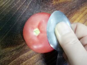 用勺子稍微带点劲在西红柿的表皮上刮，然后去皮切块备用