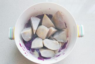 蒸熟的紫薯和芋头放入大碗中，趁热加入适量白糖和炼乳；