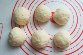 然后将发酵好的面团取出挤压排气，再分成均匀的6等份滚圆，盖保鲜膜醒发15分钟左右； 