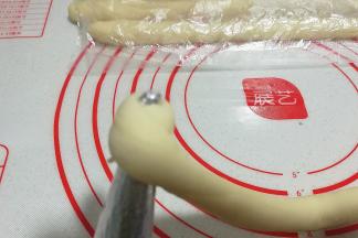 取一个螺管模具将起始端压扁，自螺管尖端处开始卷起；