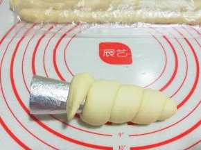 将面团一圈圈缠绕卷起，收尾末端处也压扁；