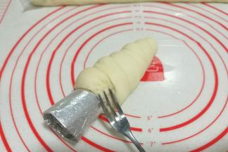 将收尾处塞入底部，可用小叉子挑起面团将尾端塞入；

