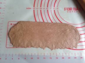 将松驰后的面团擀成长椭圆形，长边压薄