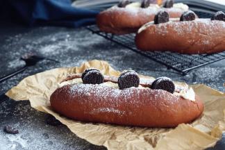 面包做好后，取出晾凉，用面包刀在面包上方中间切开，淡奶油加糖隔冰水打发，装进裱花袋，将奶油挤在切口里面，放上奥利奥小饼干，最后撒上糖霜即可