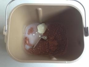 将水、糖、盐、奶粉和可可粉倒入面包桶里