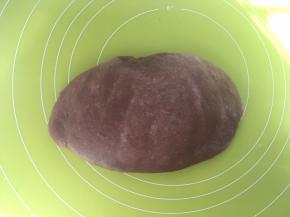 将面团取出，在揉面垫上按压排气