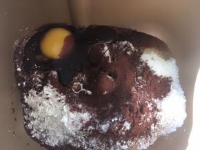 面包桶内加入高筋面粉、全麦面粉、砂糖、酵母、鸡蛋，可可粉