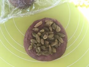 包裹上一半葡萄干，多次对折面团，将葡萄干跟面团揉均匀