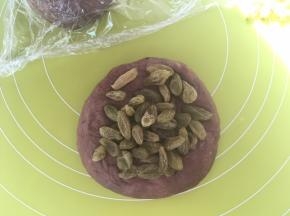 包裹上一半葡萄干，多次对折面团，将葡萄干跟面团揉均匀