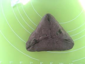 之后翻转个面，将光滑的一面朝下，对折起三面成三角形，将对折处捏紧