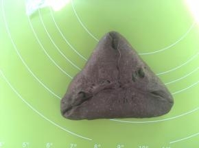 之后翻转个面，将光滑的一面朝下，对折起三面成三角形，将对折处捏紧