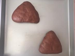 收口朝下放在烤盘内，再整理好形状，盖保鲜膜二次发酵，这段时间我家里室温特别高，26度，所以我就没有烤箱来发酵，温度低的可以烤箱放碗热水来发酵