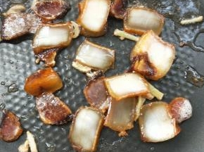 全程中小火，倒入腊肉片，翻炒至腊肉变透明。