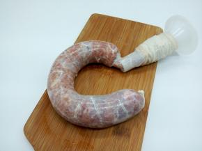 把搅打上劲后的肉馅装入灌肠器，一点点罐入肠衣