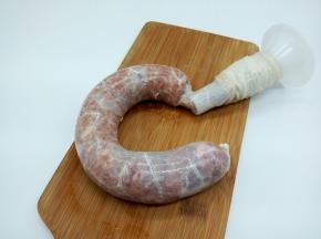 把搅打上劲后的肉馅装入灌肠器，一点点罐入肠衣