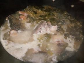 加一勺盐，大火煮至鱼骨熟，把酸菜，鱼骨捞出放入大盘，