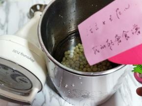 将泡好的黄豆倒入豆浆机中，加入适量的纯净水。