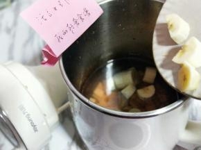 将切好的香蕉倒入豆浆机中。