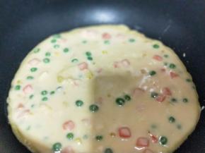 平底不粘锅中刷一层玉米油，之后再将做好的饼糊倒入锅中。