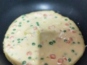 平底不粘锅中刷一层玉米油，之后再将做好的饼糊倒入锅中。