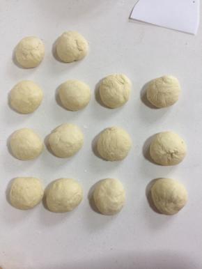发酵好的面团取出来充分排气后，均分成14个小面团（每个面团70克），揉圆盖上保鲜膜松弛15分钟。