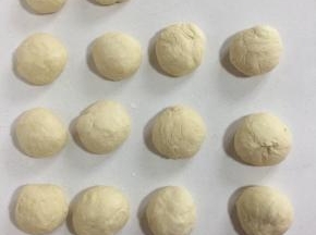 发酵好的面团取出来充分排气后，均分成14个小面团（每个面团70克），揉圆盖上保鲜膜松弛15分钟。