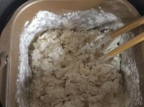 用筷子搅拌一下，以免揉面的时候面粉飞溅。