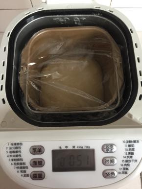 面团取出来揉圆，放进面包机中，盖上保鲜膜，选择发酵键进行发酵。（大约1小时）