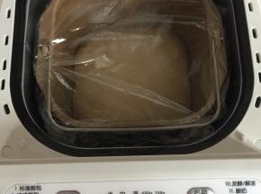 面团取出来揉圆，放进面包机中，盖上保鲜膜，选择发酵键进行发酵。（大约1小时）