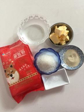 用电子秤称出所需食材：
面包粉500克，温水320克，盐2克，酵母6克，黄油50克，糖100克。