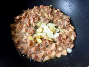 兔肉微微发黄放入姜片和蒜片翻炒出香味。