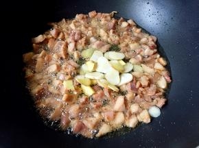 兔肉微微发黄放入姜片和蒜片翻炒出香味。