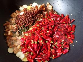 接着放入花椒、辣椒和八角小火煸炒。