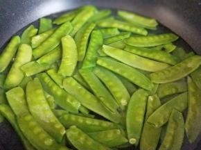 荷兰豆焯水，水烧开后，倒入处理好的荷兰豆，再次烧开捞出，立即过冷水，捞出淋干水份。