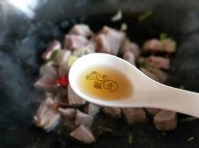 待猪肉炒至变色后加入料酒。