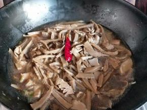 再把泡发的笋干盖在猪肉上面，盖上盖子大火烧开，转小火多45分钟左右