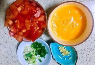 鸡蛋打入碗，加半勺盐调均匀，番茄用食盐浸泡洗净切一指见宽的丁，小葱切葱花，老姜末