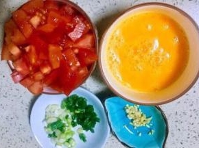 鸡蛋打入碗，加半勺盐调均匀，番茄用食盐浸泡洗净切一指见宽的丁，小葱切葱花，老姜末
