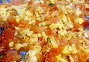 鸡蛋液膨胀凝固倒入番茄丁翻炒，加入少许盐，炒至番茄软烂出汁，装碗备用