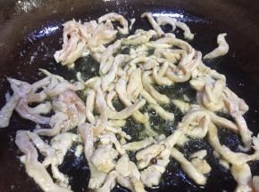 七成热时倒入鸡肉丝快速翻炒至变白