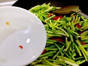 倒入蒜苔，翻炒几分钟，期间撒一点水，然后倒入生抽，继续撒一点水翻炒