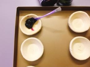 用勺子舀入一勺蓝莓酱放入蛋挞皮中
