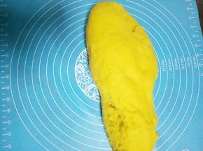 然后把面团放入揉面垫开始揉面，先把面团摔出去