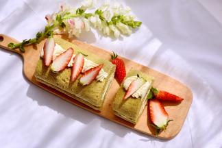 取出蛋糕卷，表面挤点奶油，放上草莓即可食用