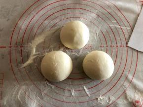 把发酵好的面团进行排气，揉的越彻底越好，直到切开面团看不见气孔。然后平均分成三份，揉圆。